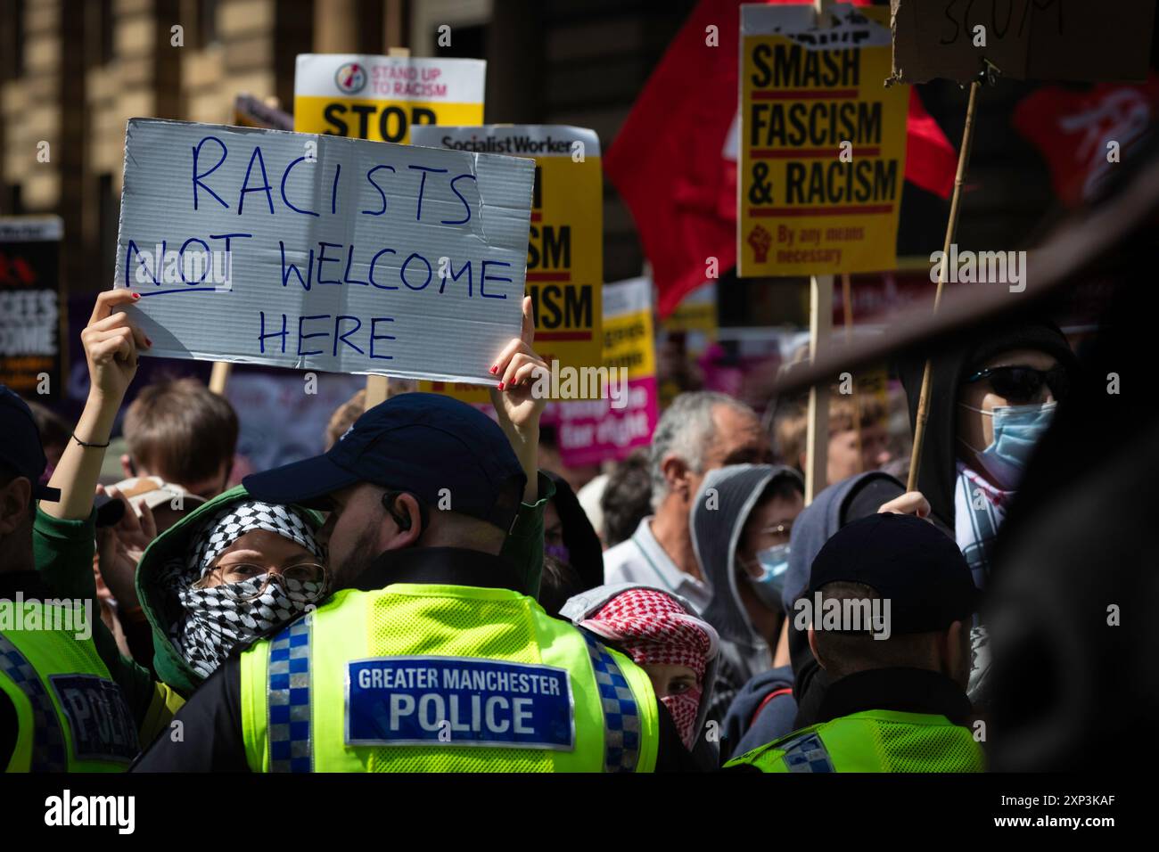 Manchester, Regno Unito. 3 agosto 2024. Un manifestante tiene un cartello durante una manifestazione di unità Stand Up to Racism contro i sostenitori anti-immigrazione. All'inizio di questa settimana, proteste e rivolte sono scoppiate in tutto il paese dopo un orribile attacco con coltello a Southport, un ragazzo di 17 anni che ha ucciso tre bambini innocenti. La disinformazione sull'aggressore si è diffusa sui social media, riportando che era un richiedente asilo, il che in seguito si è rivelato inesatto. Credito: SOPA Images Limited/Alamy Live News Foto Stock