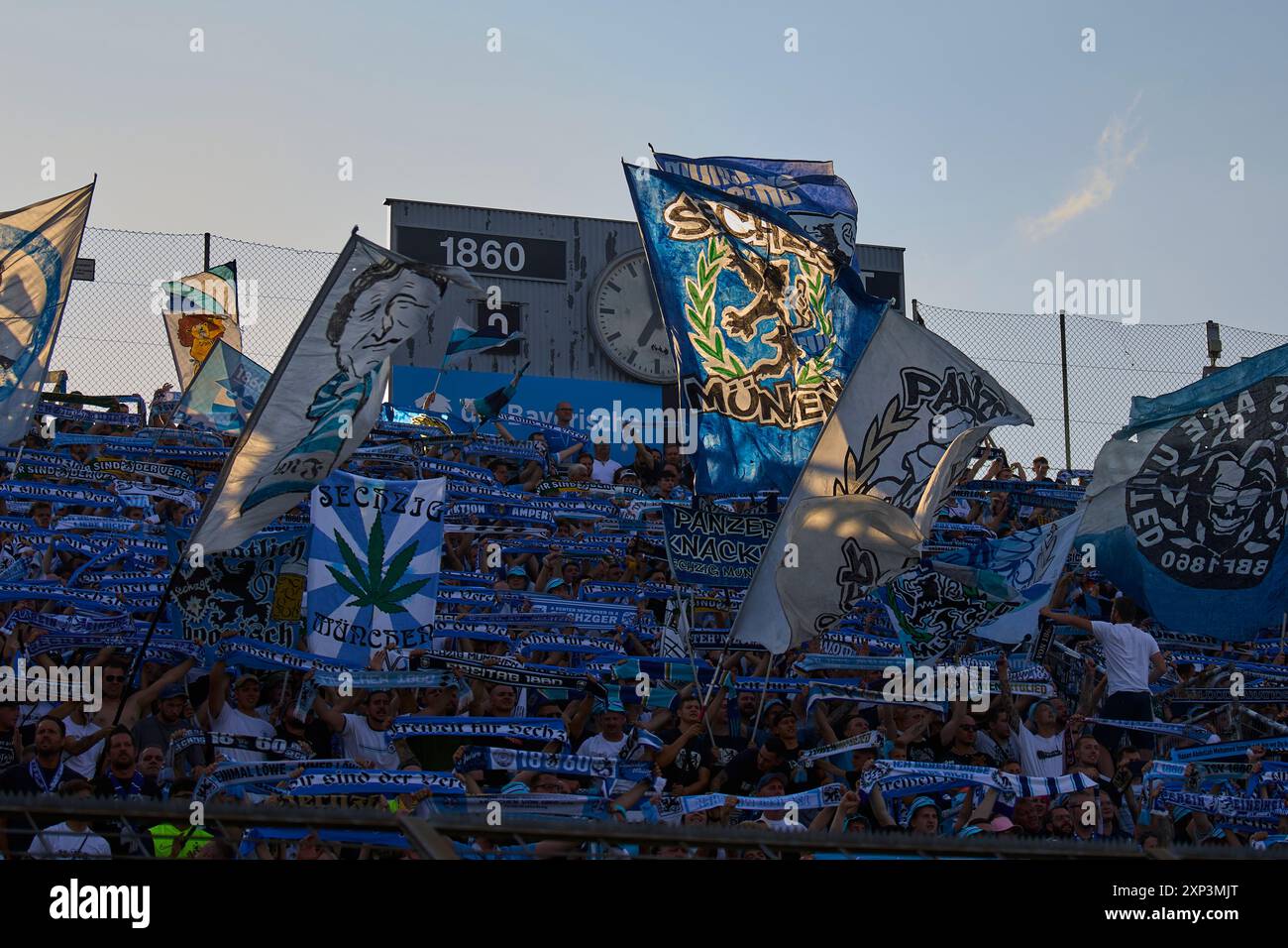 Monaco, Germania. 2 agosto 2024. Tifosi della TSV 1860 con la bandiera del Monaco Franze Helmut Fischer alla partita 3.Liga TSV 1860 Muenchen - 1. FC Saarbruecken 0-1 nello Stadion an der Gruenwalder Strasse al 2 agosto 2024 a Monaco, Germania. Stagione 2024/2025, 3.German Soccer League fotografo: ddp Images/STAR-Images crediti: ddp media GmbH/Alamy Live News Foto Stock