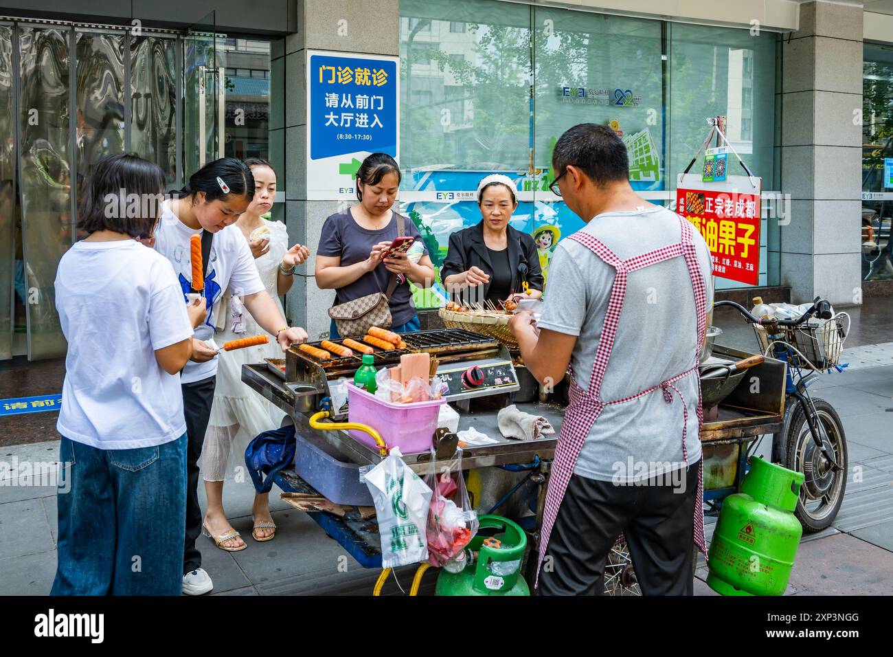 Donne che mangiano cibo di strada a Chengdu, Sichuan, Cina. Foto Stock