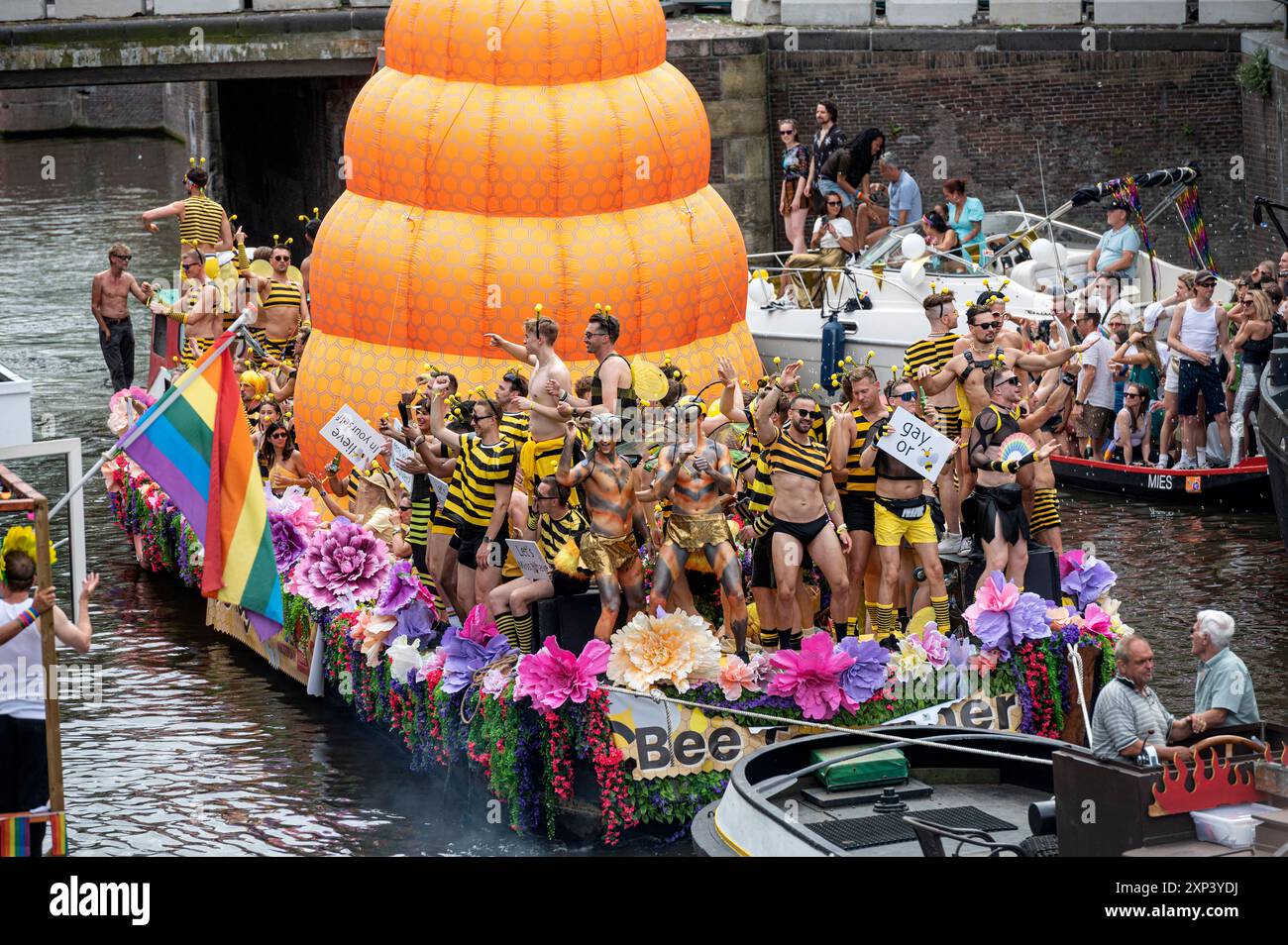 Amsterdam, Paesi Bassi, 3 agosto 2024 Una processione di barche dai colori vivaci si snoda attraverso i canali di Amsterdam per l'annuale Pride Canal Parade. Le folle fiancheggiano il canale. De Beebiboot il Bee-bi-boot. lgbt, lgbtqi, olandese, olanda, nederland, gay, prinsengracht Foto Stock