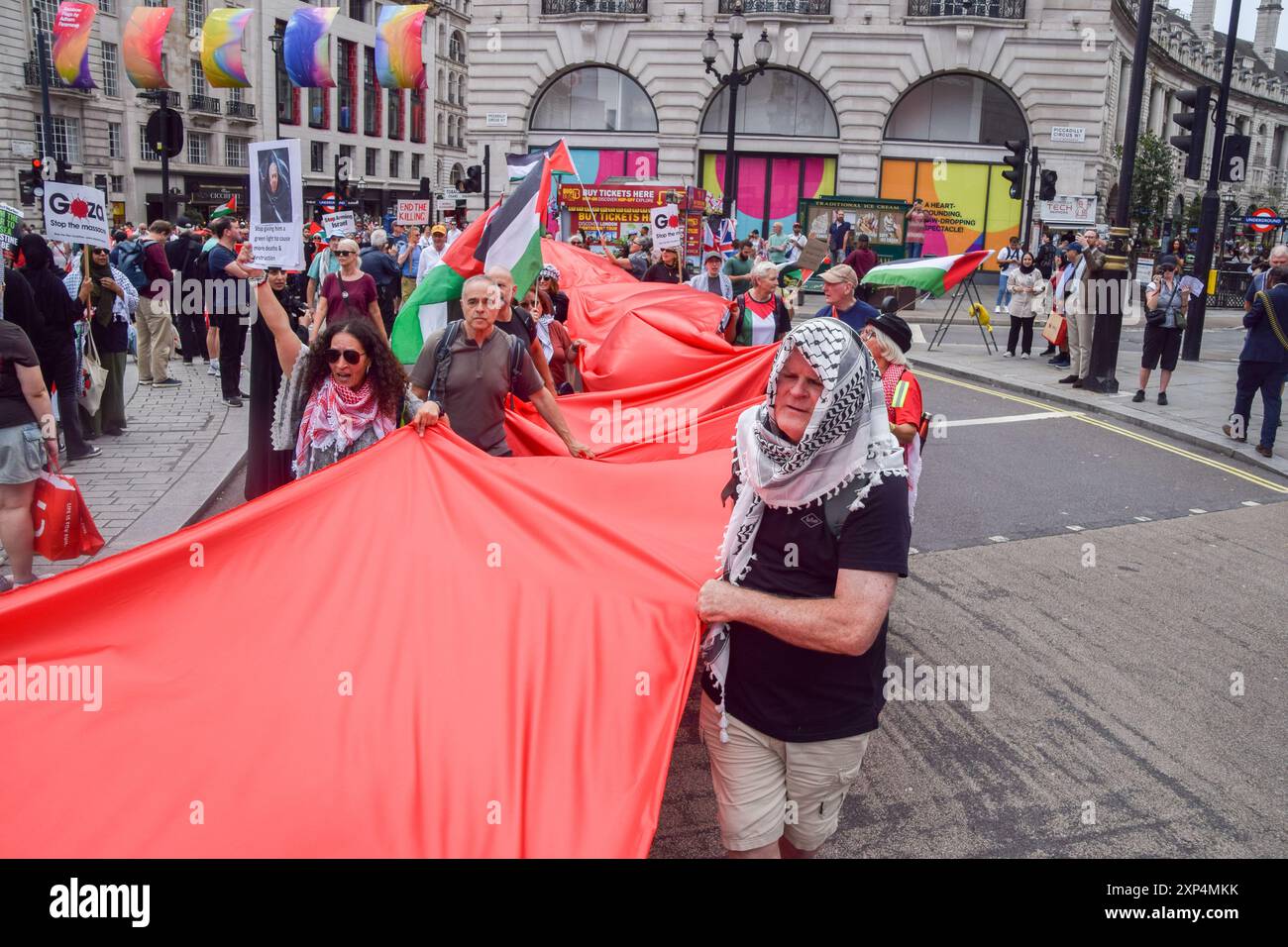Londra, Regno Unito. 3 agosto 2024. I manifestanti hanno un tessuto rosso molto lungo durante la marcia a Piccadilly Circus. Migliaia di persone hanno marciato in solidarietà con la Palestina chiedendo un cessate il fuoco e invitando il governo britannico a smettere di armare Israele mentre la guerra a Gaza continua. Credito: SOPA Images Limited/Alamy Live News Foto Stock