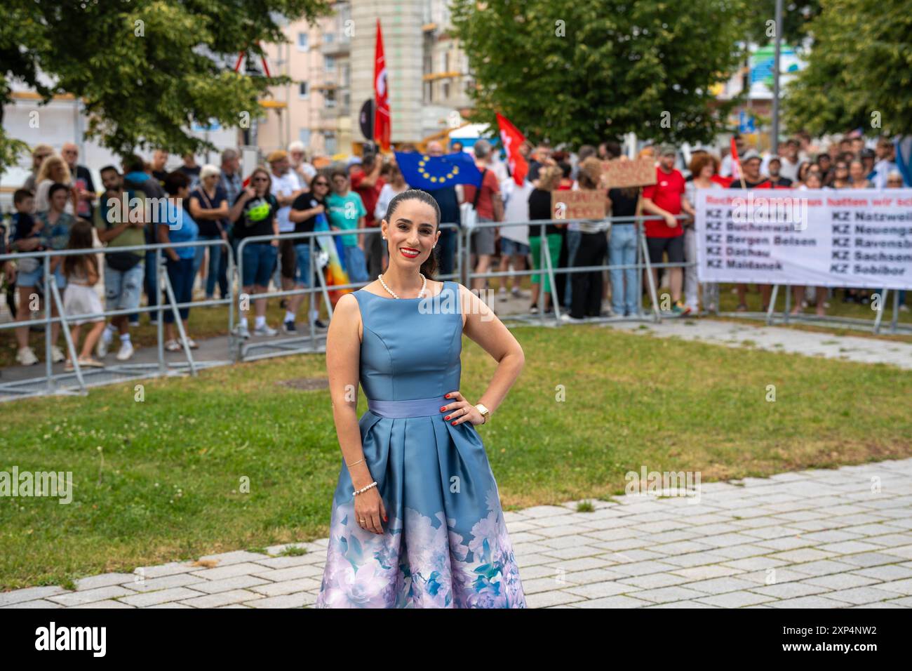 Meitingen, Baviera, Germania - 3 agosto 2024: Gabrielle Mailbeck, presidente locale dell'AFD - alternative for Germany party in Meitingen Augsburg District in Baviera in occasione di una festa. Manifestanti contro il partito sullo sfondo *** Gabrielle Mailbeck Ortsvorsitzende der Partei AFD - alternative für Deutschland a Meitingen Landkreis Augsburg a Bayern bei einer Veranstaltung der Partei. Demonstranten gegen die Partei im Hintergrund Foto Stock