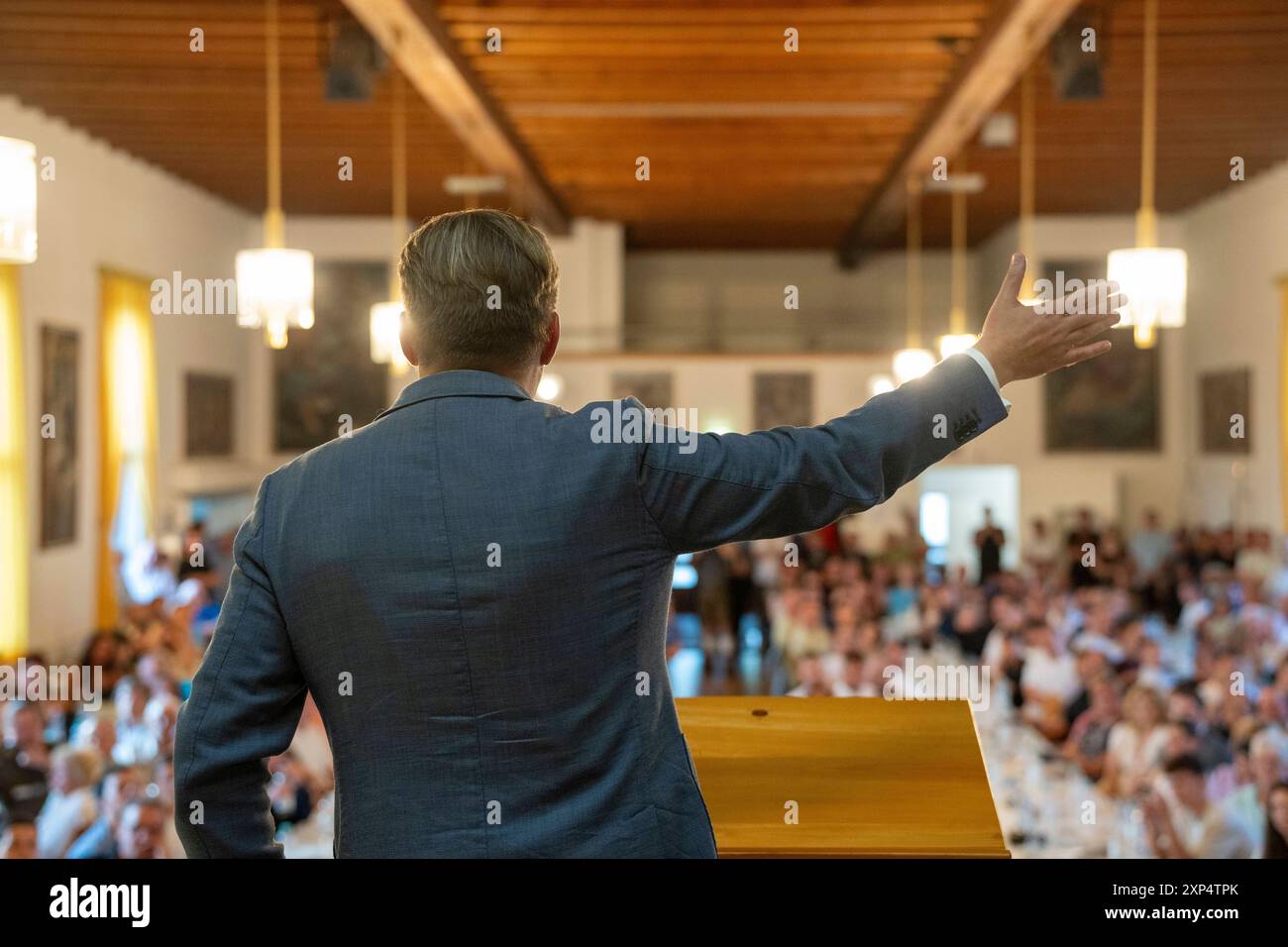 Meitingen, Baviera, Germania - 3 agosto 2024: Maximilian Krah von hinten, politico dell'AfD - alternativa per la Germania, in visita in Baviera a Meitingen, tiene un discorso sul palco davanti a un pubblico. *** Maximilian Krah von hinten, Politiker der AfD - alternative für Deutschland, zu Besuch in Bayern Meitingen, hält eine Rede auf der Bühne vor Publikum. Foto Stock