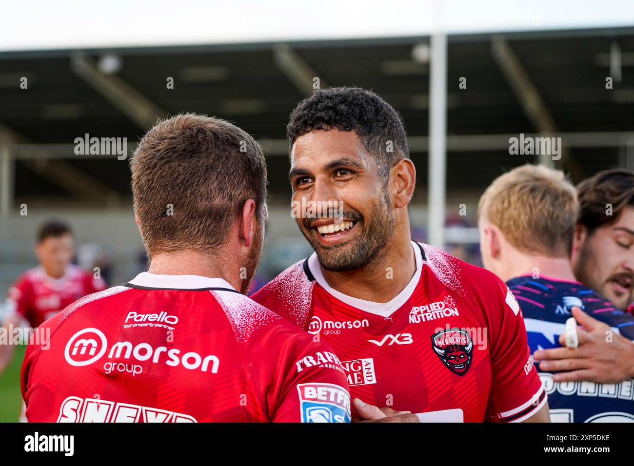 Salford, Manchester, Regno Unito. 3 agosto 2024. Super League Rugby: Salford Red Devils vs Leeds Rhinos al Salford Community Stadium. Nene Macdonalnd e Marc Sneyd condividono un momento dopo la loro vittoria sui Leeds Rhinos. Credito James Giblin/Alamy Live News. Foto Stock