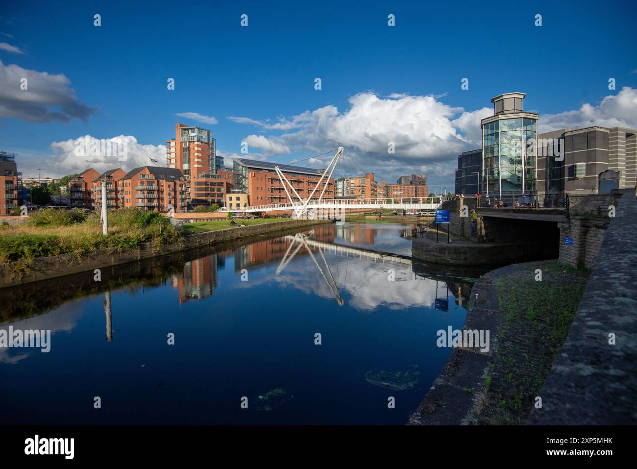 Il fiume Aire con il Knight's Way Bridge con appartamenti sul lato nord (a destra) e il Royal Armouries Museum sul lato sud, Leeds, West Yorkshire Foto Stock