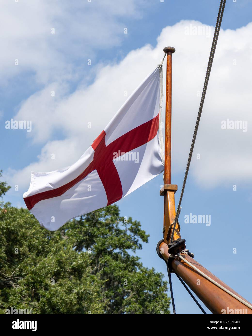 Croce di San Giorgio, bandiera di nave britannica che sventola alla prua di una nave ricostruita degli anni '1600, utilizzata per viaggiare nel nuovo mondo dagli esploratori. Foto Stock
