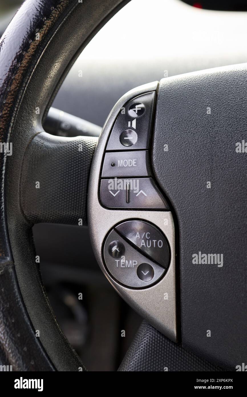 Elemento interno del volante dell'auto elettrica ibrida con pulsante di comando della climatizzazione del condizionatore e multimediale Foto Stock