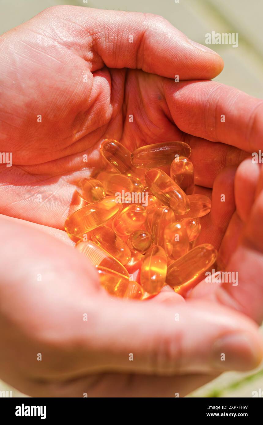 molte capsule di olio di fegato di merluzzo sono nelle mani di. Foto di alta qualità Foto Stock