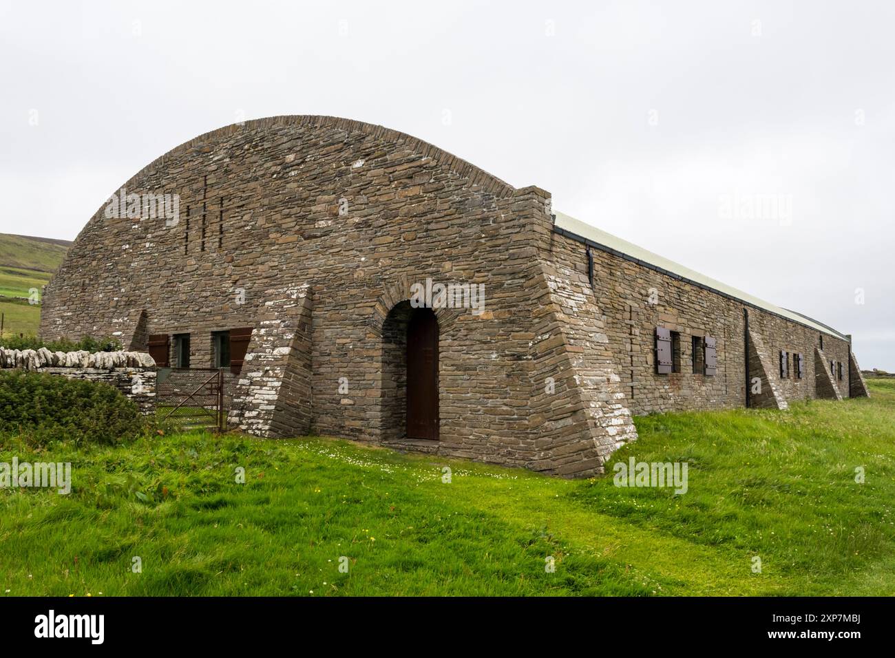 Il moderno edificio in pietra che racchiude Midhowe Chambered Cairn a Rousay, nelle Orcadi. Foto Stock