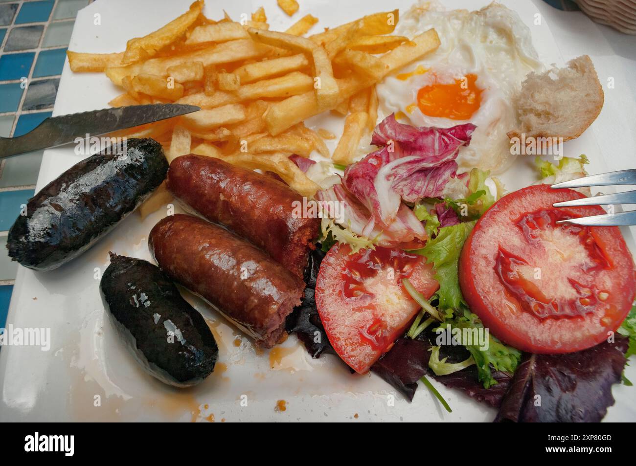Piatto spagnolo classico con Chorizo, salsiccia di sangue, uovo fritto e patatine fritte. Foto Stock