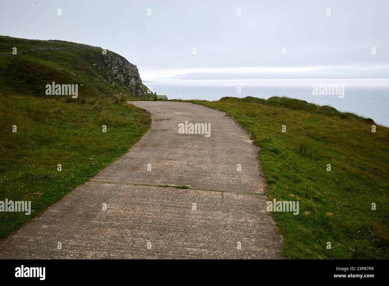 tortuosa strada in cemento a binario singolo in cima alla scogliera nella riserva naturale kerebble e kinramer rathlin island, contea di antrim, irlanda del nord, regno unito Foto Stock