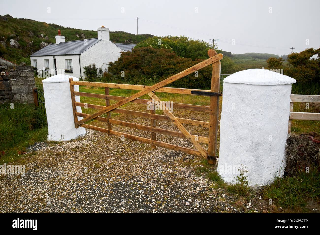 tradizionali pilastri di pietra bianca con 5 porte di legno ingresso al cottage rathlin island, contea di antrim, irlanda del nord, regno unito Foto Stock