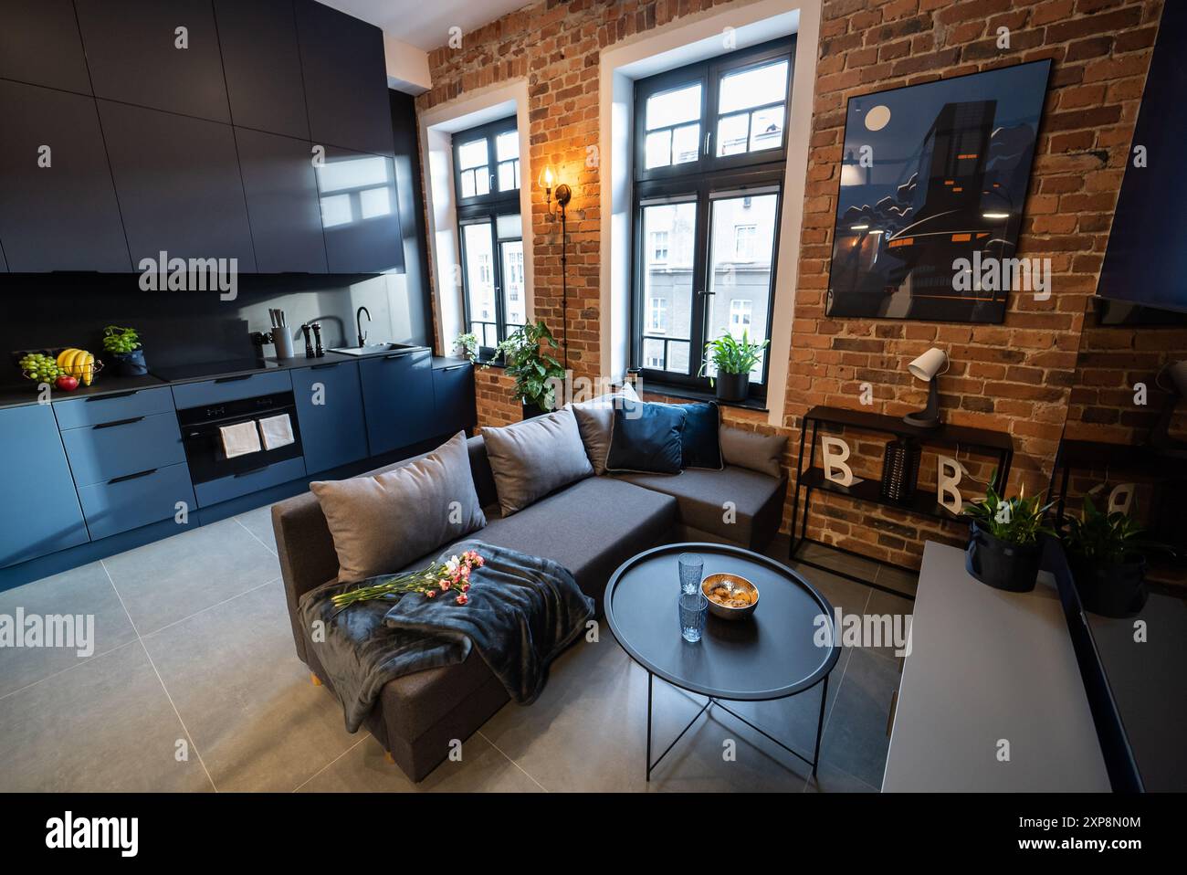 Elegante cucina collegata perfettamente a un accogliente soggiorno. Cucina moderna collegata al soggiorno in un piccolo appartamento. Cucina moderna Foto Stock
