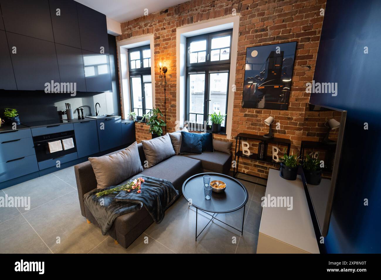 Elegante cucina collegata perfettamente a un accogliente soggiorno. Cucina moderna collegata al soggiorno in un piccolo appartamento. Cucina moderna Foto Stock