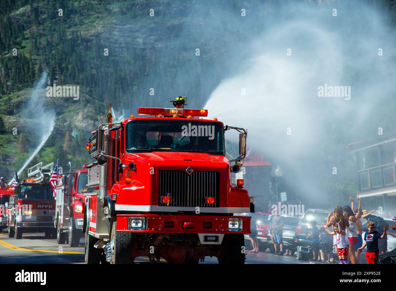 I vigili del fuoco locali usano il loro canyon d'acqua per spruzzare i partecipanti durante la parata del 4 luglio lungo la strada principale di Ouray, Colorado. Foto Stock