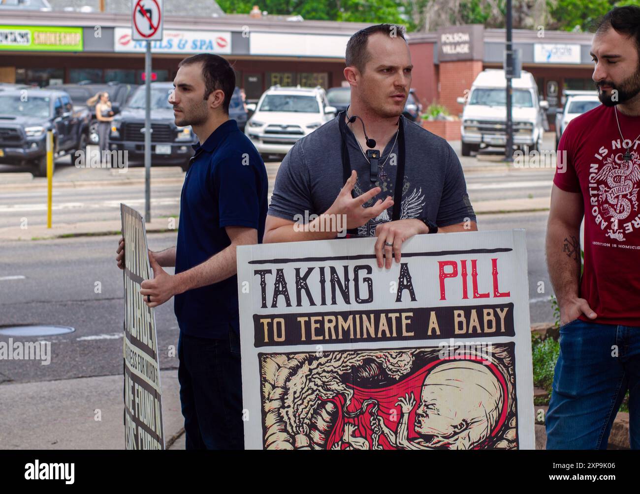 Tre attivisti del diritto alla vita protestano contro gli aborti medici a Boulder, Colorado, tre uomini con cartelli che riportano messaggi anti l'aborto stanno su un marciapiede Foto Stock