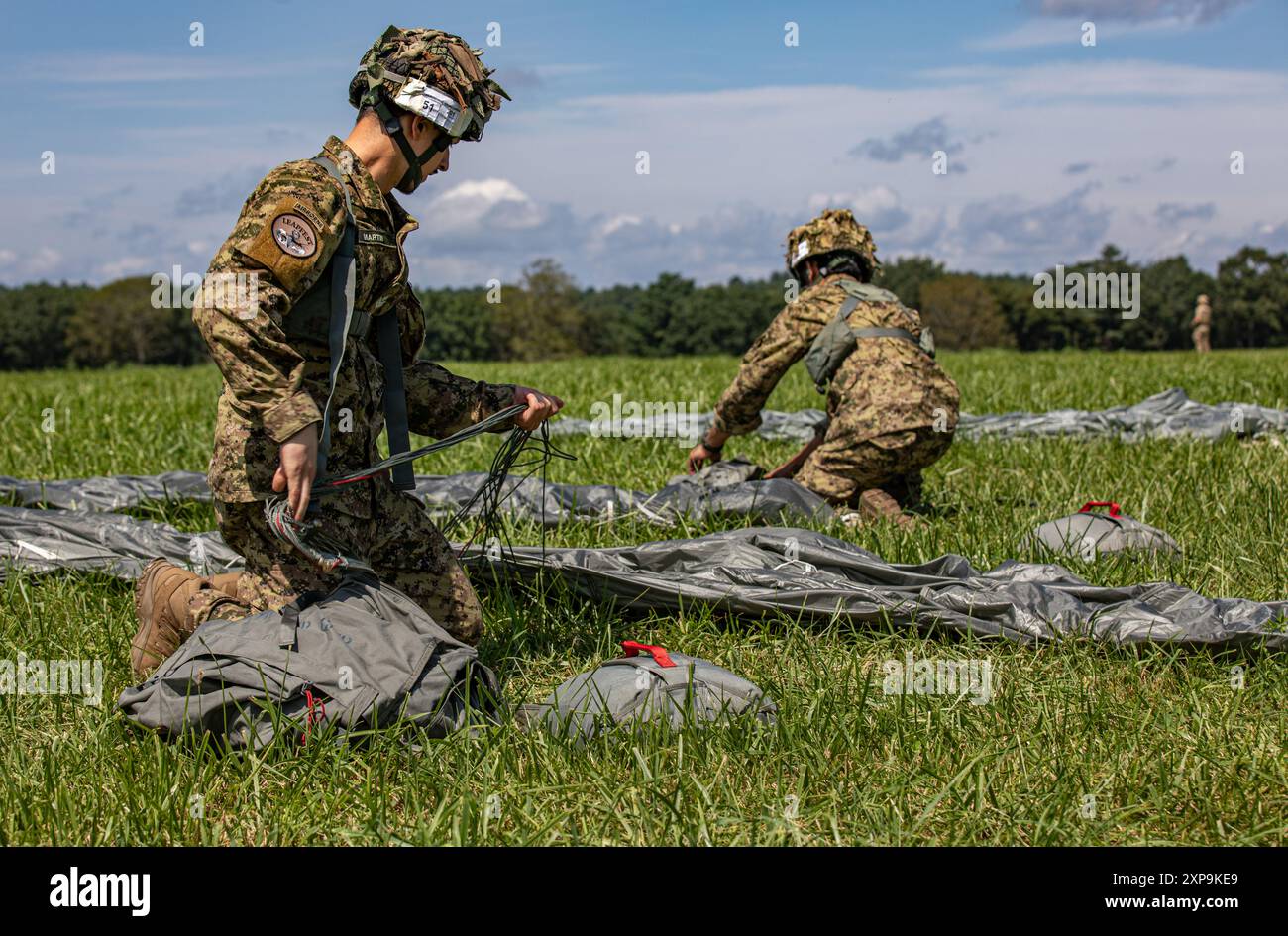 Due paracadutisti canadesi preparano i loro MC-6 Parachutes nella zona di lancio durante il Leapfest 2024 a Glenrock Drop zone, Exeter, Rhode Island, 3 agosto 2024. Il Leapfest è il più grande evento di addestramento e competizione internazionale per paracadute di linea statica ospitato dal 56th Troop Command, Rhode Island Army National Guard, per promuovere addestramento tecnico di alto livello e esprit de Corps all'interno della comunità internazionale aviotrasportata. (Foto della U.S. Army Reserve di Sgt. 1st Class Austin Berner) Foto Stock