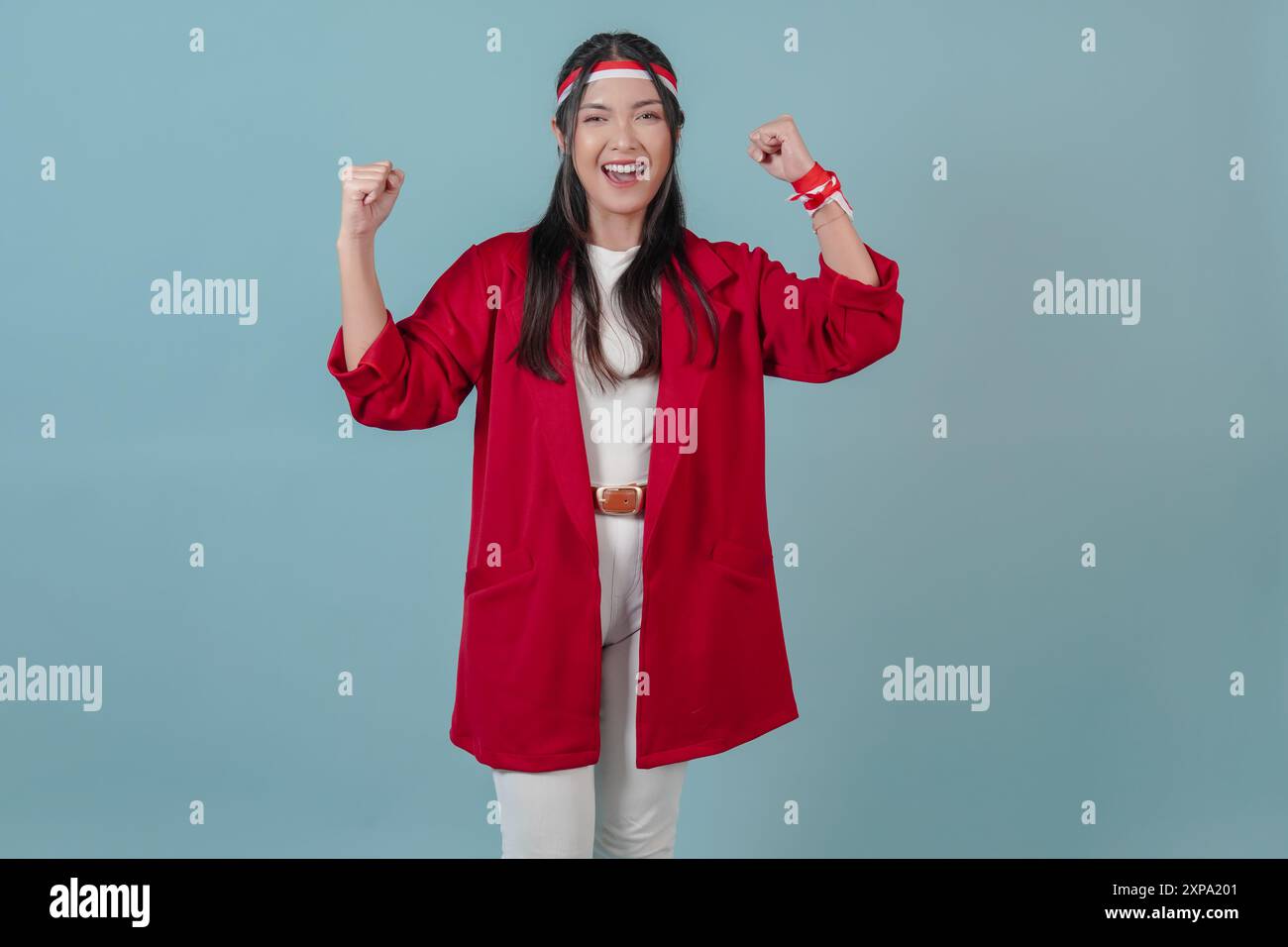 Giovane donna indonesiana con un'espressione felice che solleva le braccia in aria. Indonesia Independence Day Concept. Foto Stock