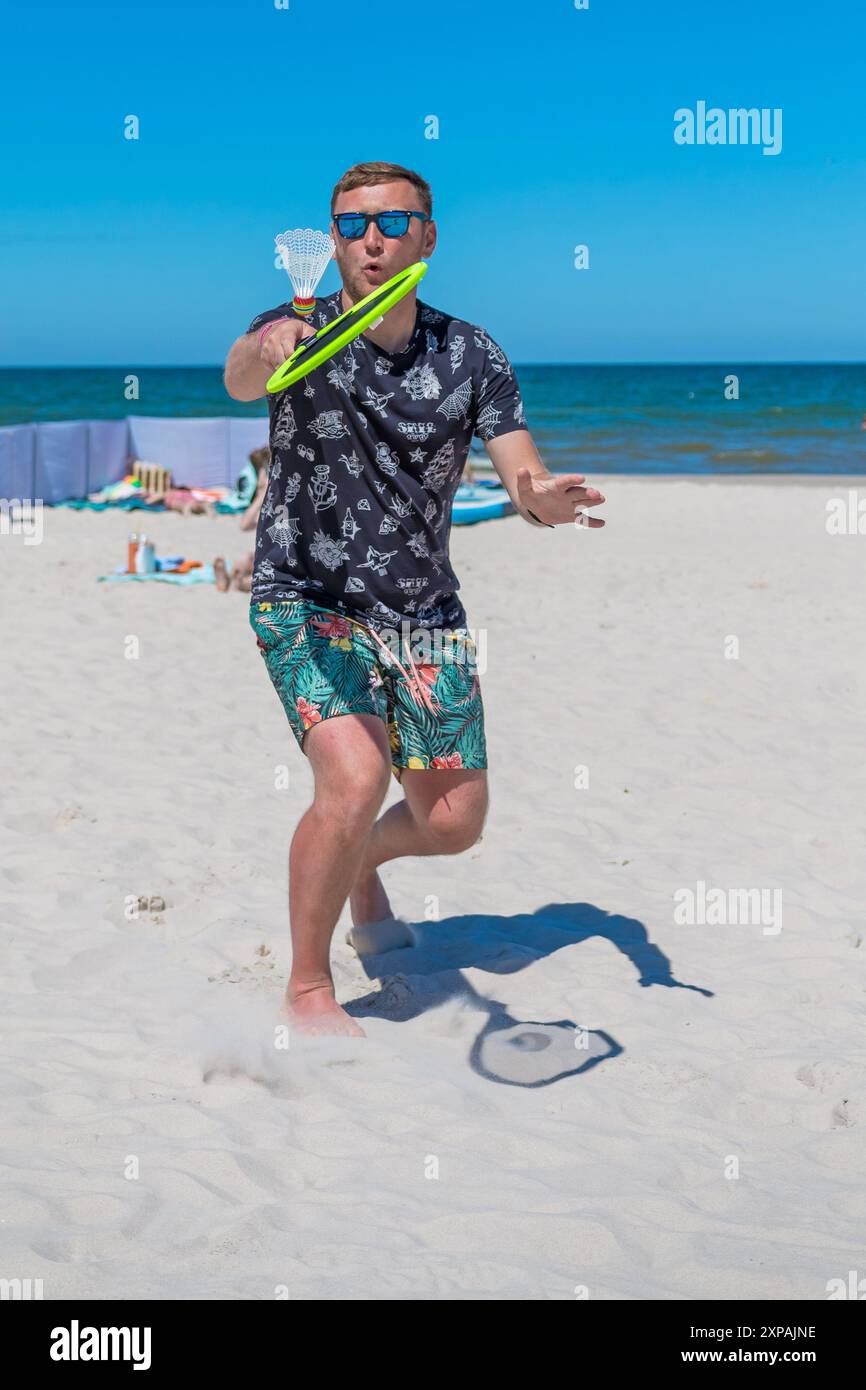 Debki, Polonia - 06.06.2023: Un giovane gioca a Beach paddleball in una giornata di sole a Dębki, Polonia Foto Stock