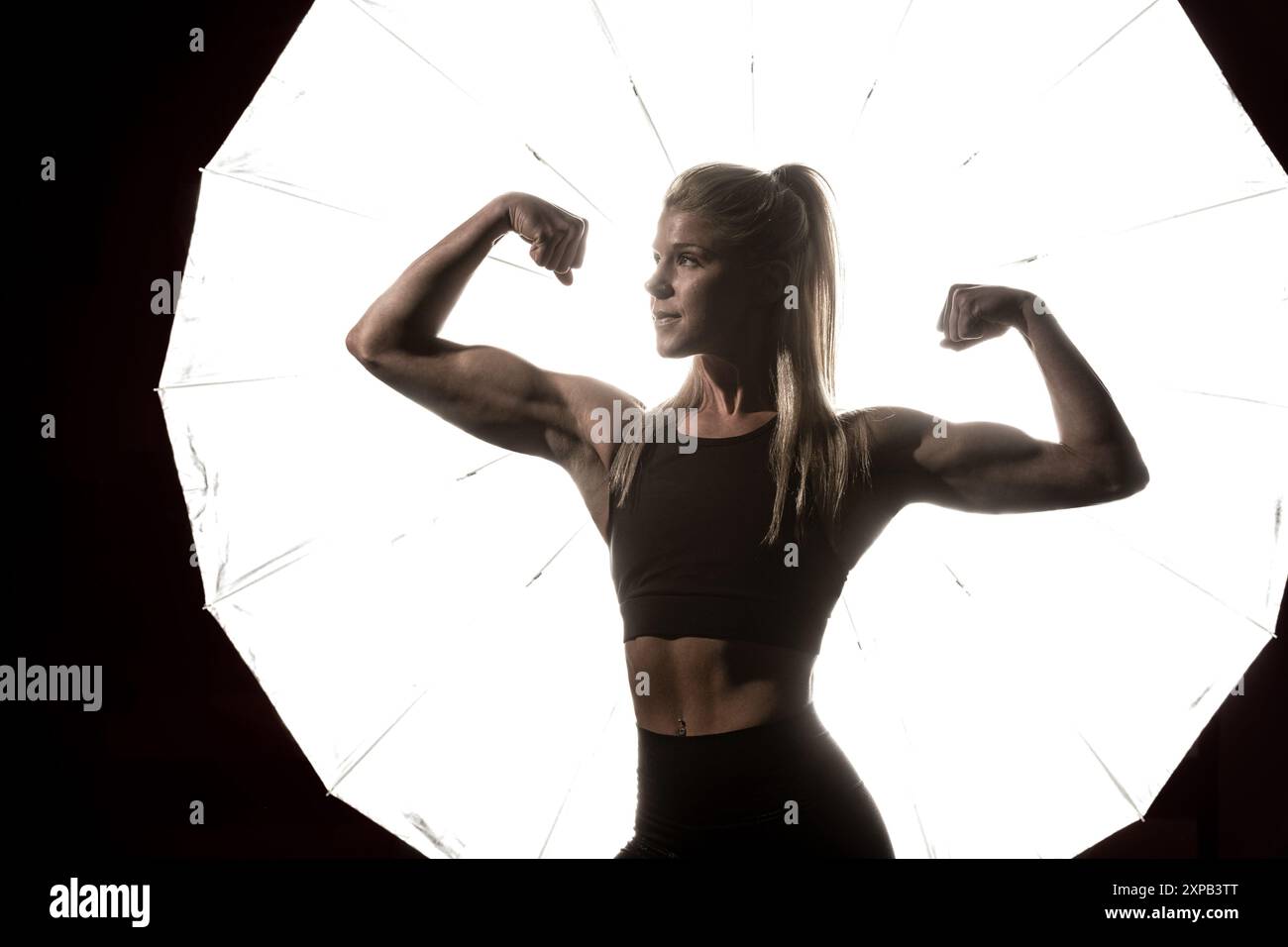 la donna mostra le sue pistole in un ritratto creativo Foto Stock