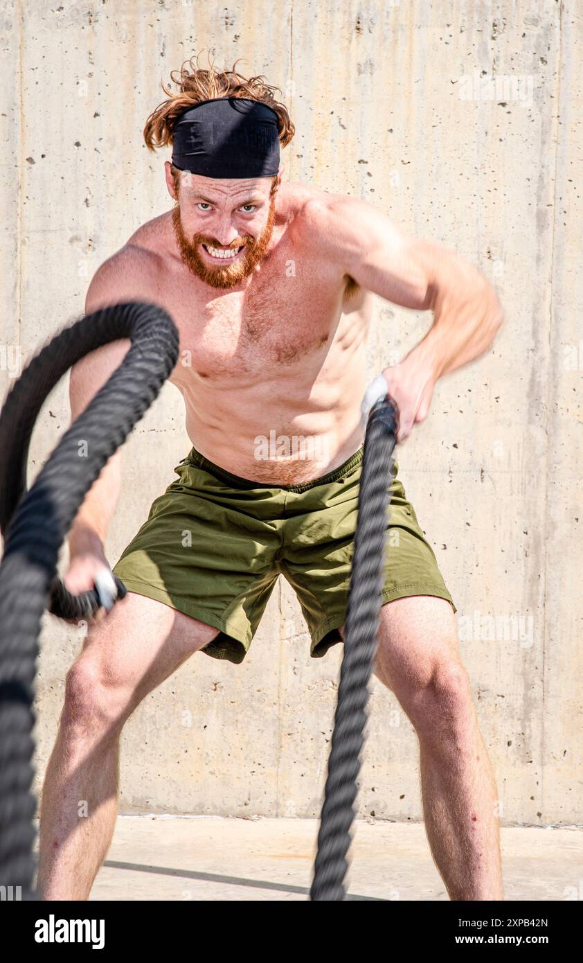 Redhead Guy fa corde da battaglia Foto Stock