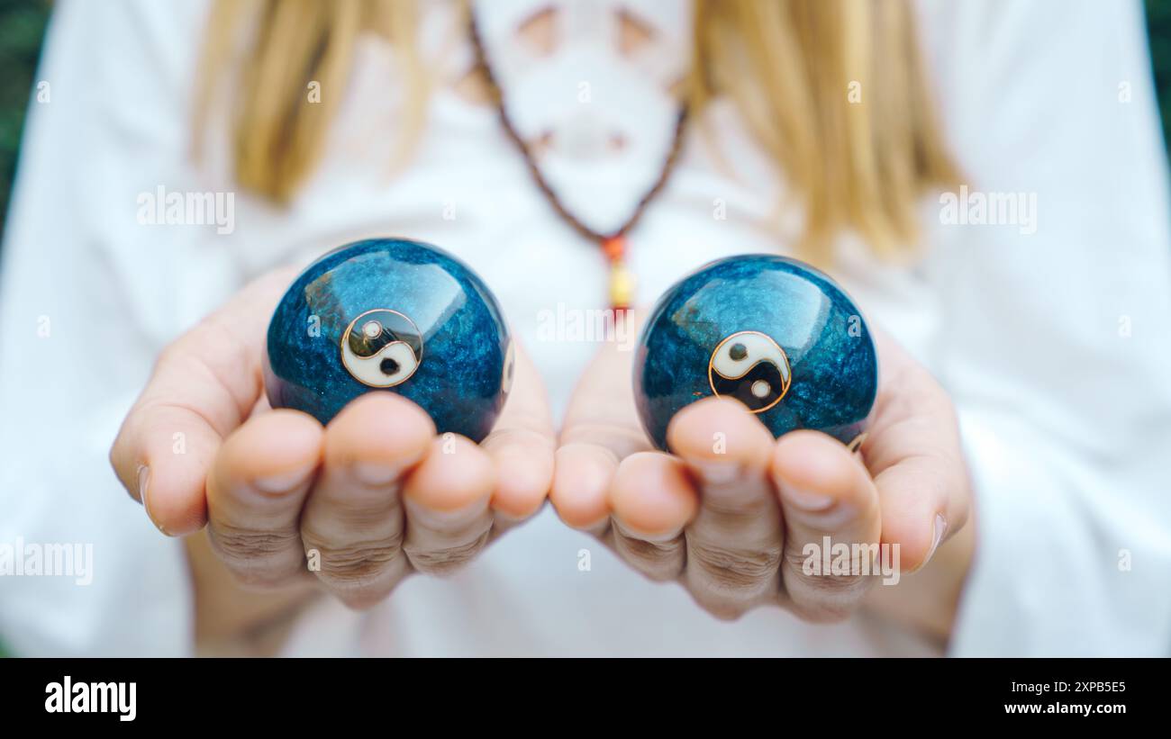 Donna che tiene le palle cinesi Foto Stock