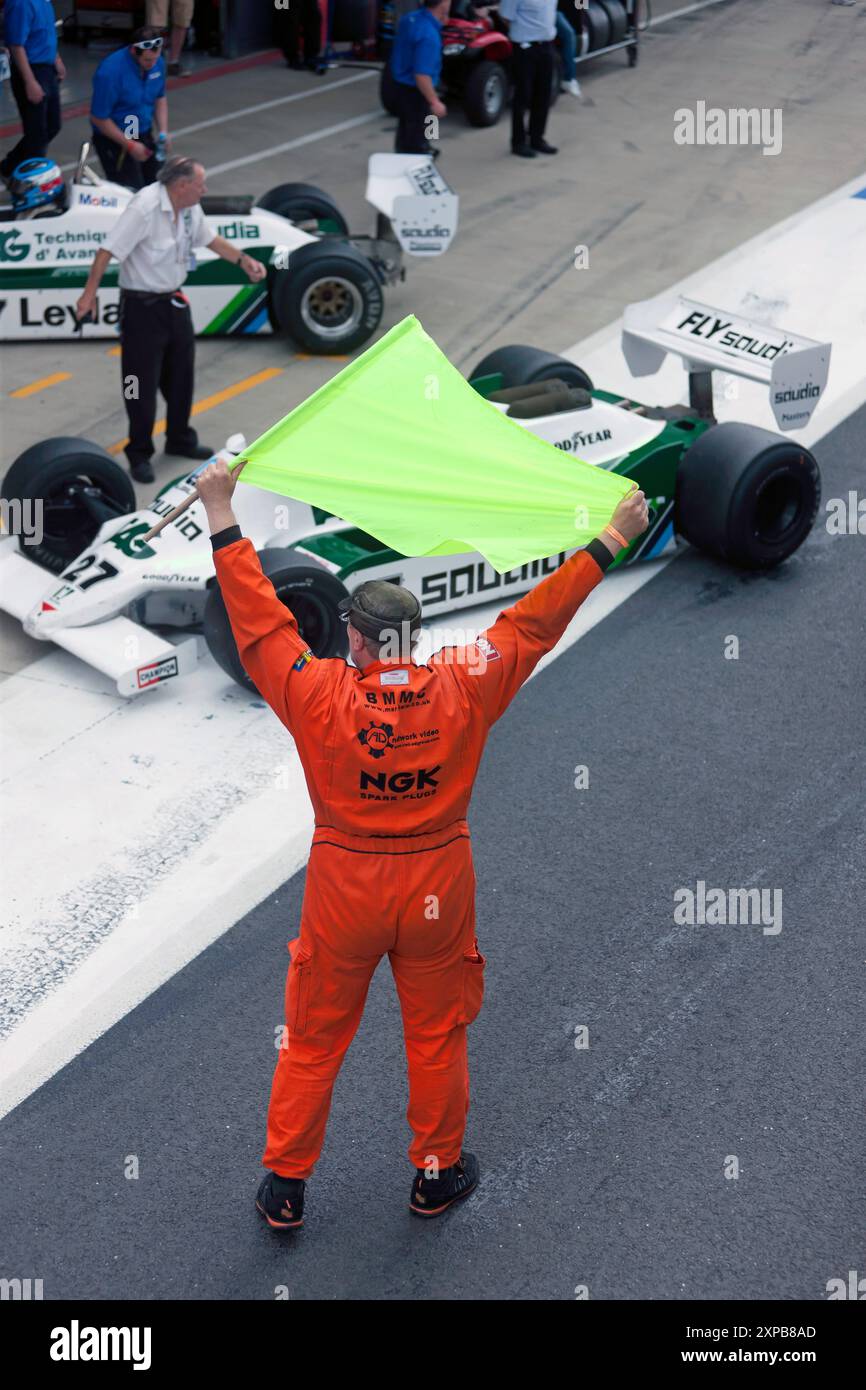 A Race Marshall, dirige le auto nella corsia International Pit, dopo la storica gara di Formula 1 FIA Masters, al Silverstone Classic 2016 Foto Stock