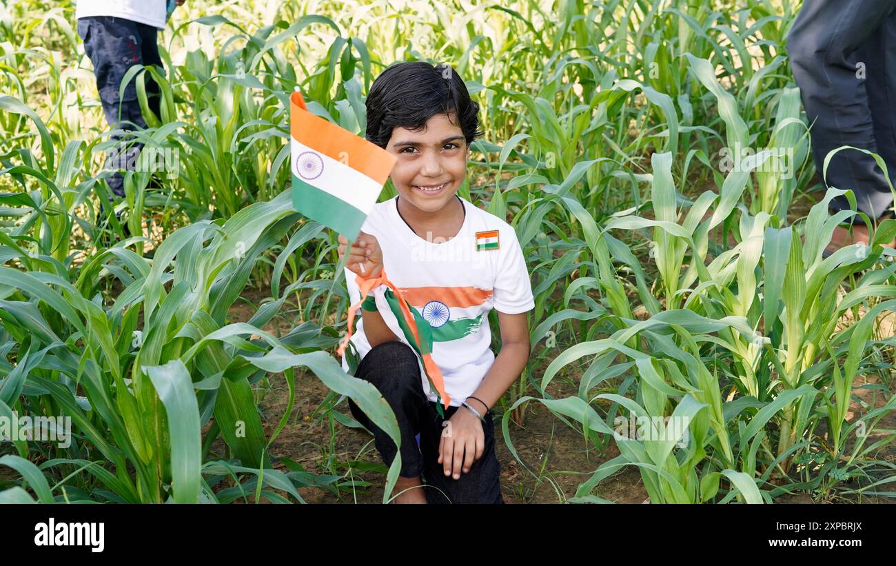 Bambini con membri della famiglia che indossano maglietta con logo bandiera indiana e che tengono in mano, sventolano o corrono con il tricolore con verde sullo sfondo, celebr Foto Stock