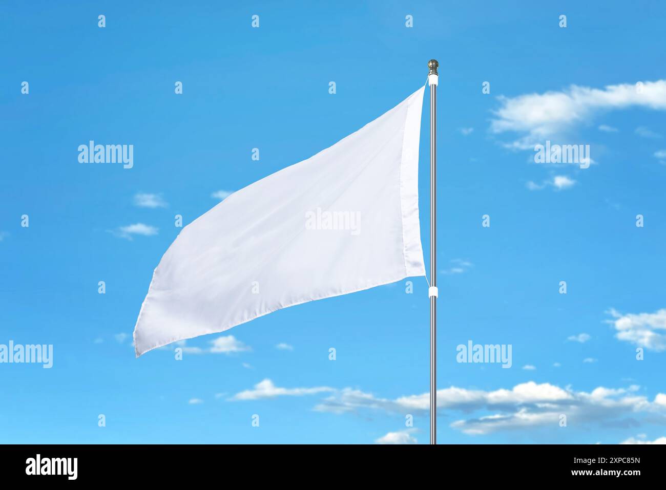 Bandiera bianca che fluttua nel vento in una giornata di sole. Ideale per i modelli, l'aggiunta di progetti o le bandiere nazionali. Cielo blu chiaro sullo sfondo Foto Stock