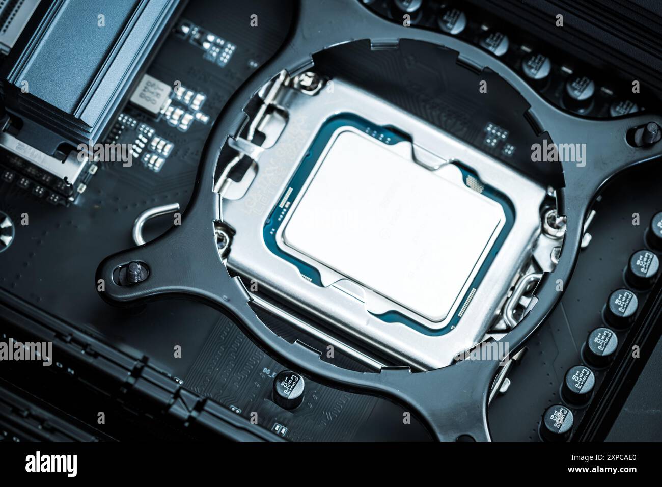 Un processore per computer è posizionato con cura nel relativo socket sulla scheda madre, mostrando il design complesso e i collegamenti. Foto Stock