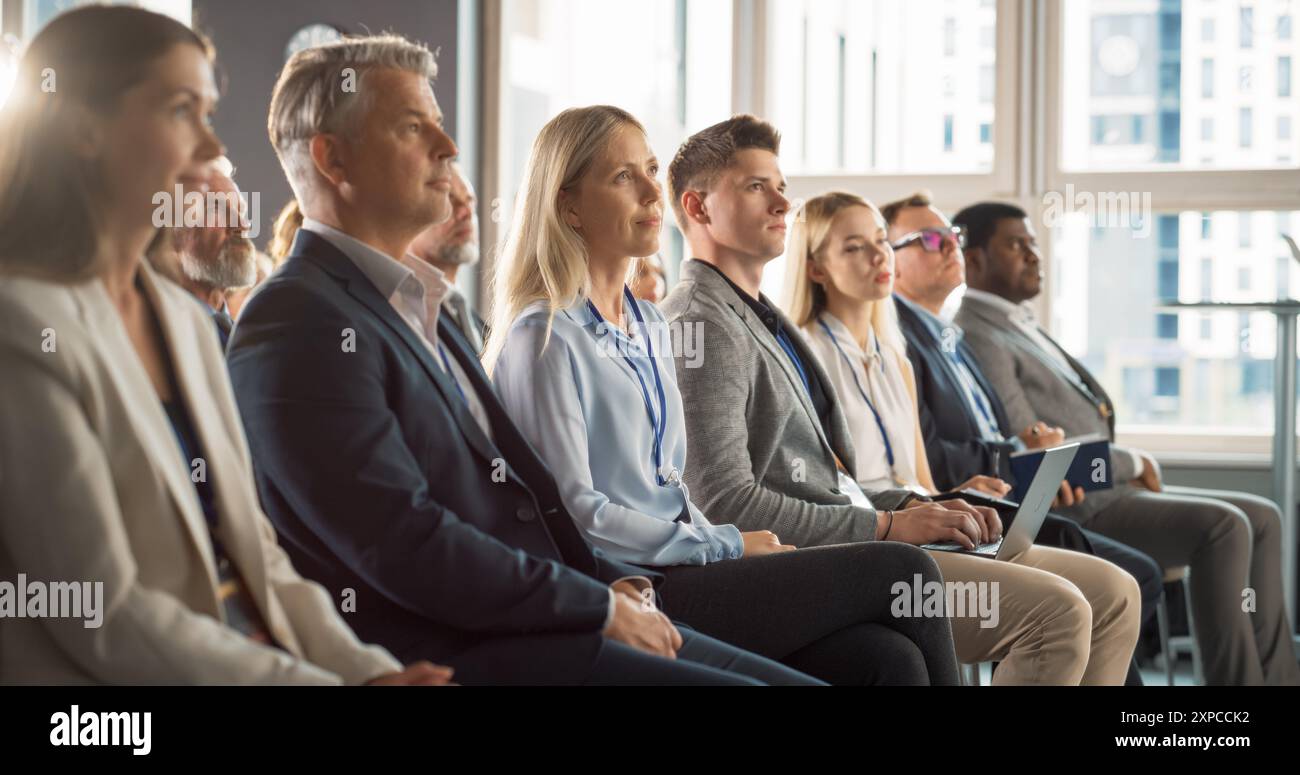 Donna caucasica seduta in un pubblico affollato alla Human Resource Conference. Delegata femminile focalizzata sul presentatore. Responsabile delle risorse umane ascoltare la presentazione sull'imprenditoria ispiratrice sugli studi sociali Foto Stock