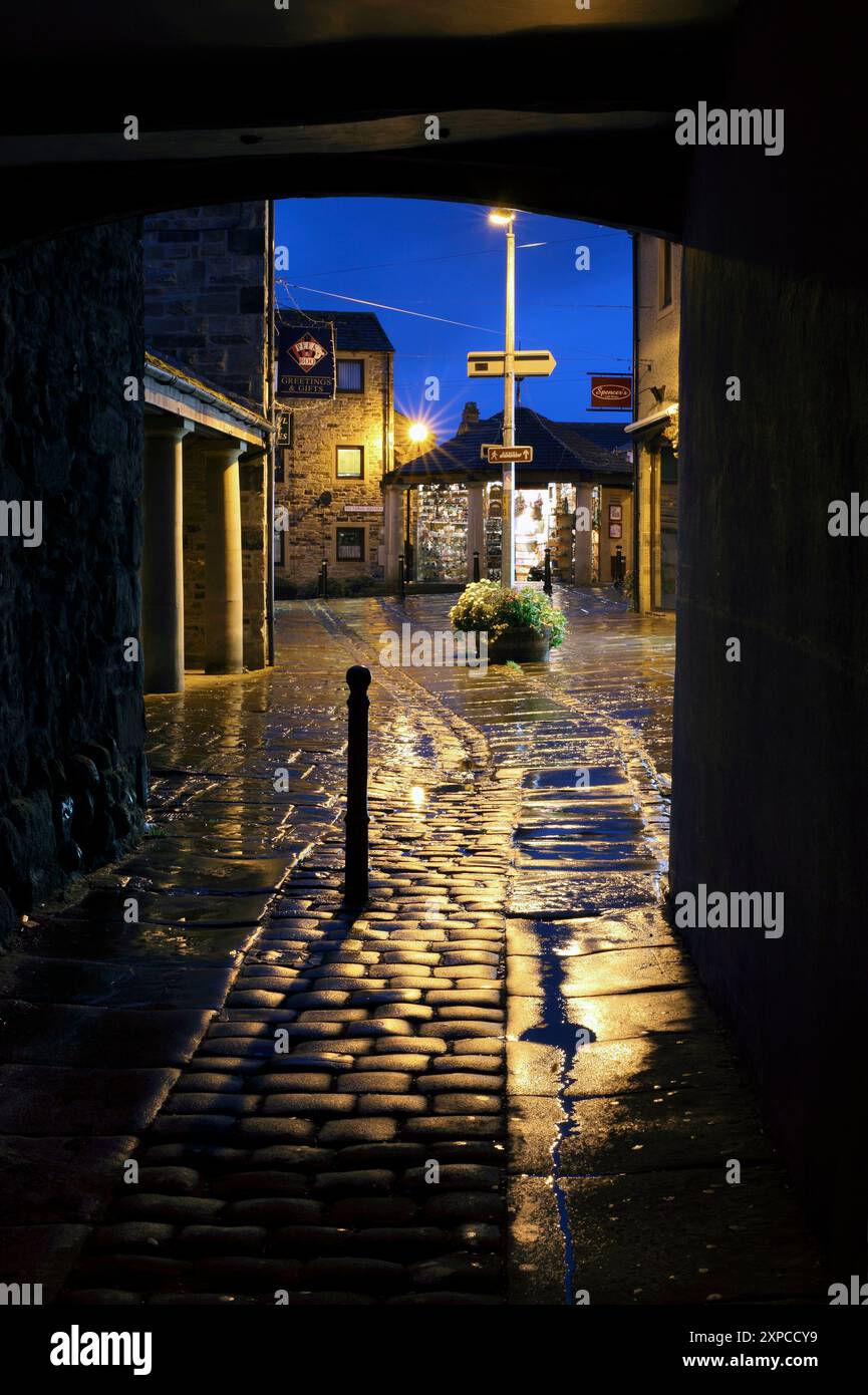 Una serata umida a Skipton, nel North Yorkshire. Guardando attraverso un arco da Sheep Street a Victoria Square. Foto Stock