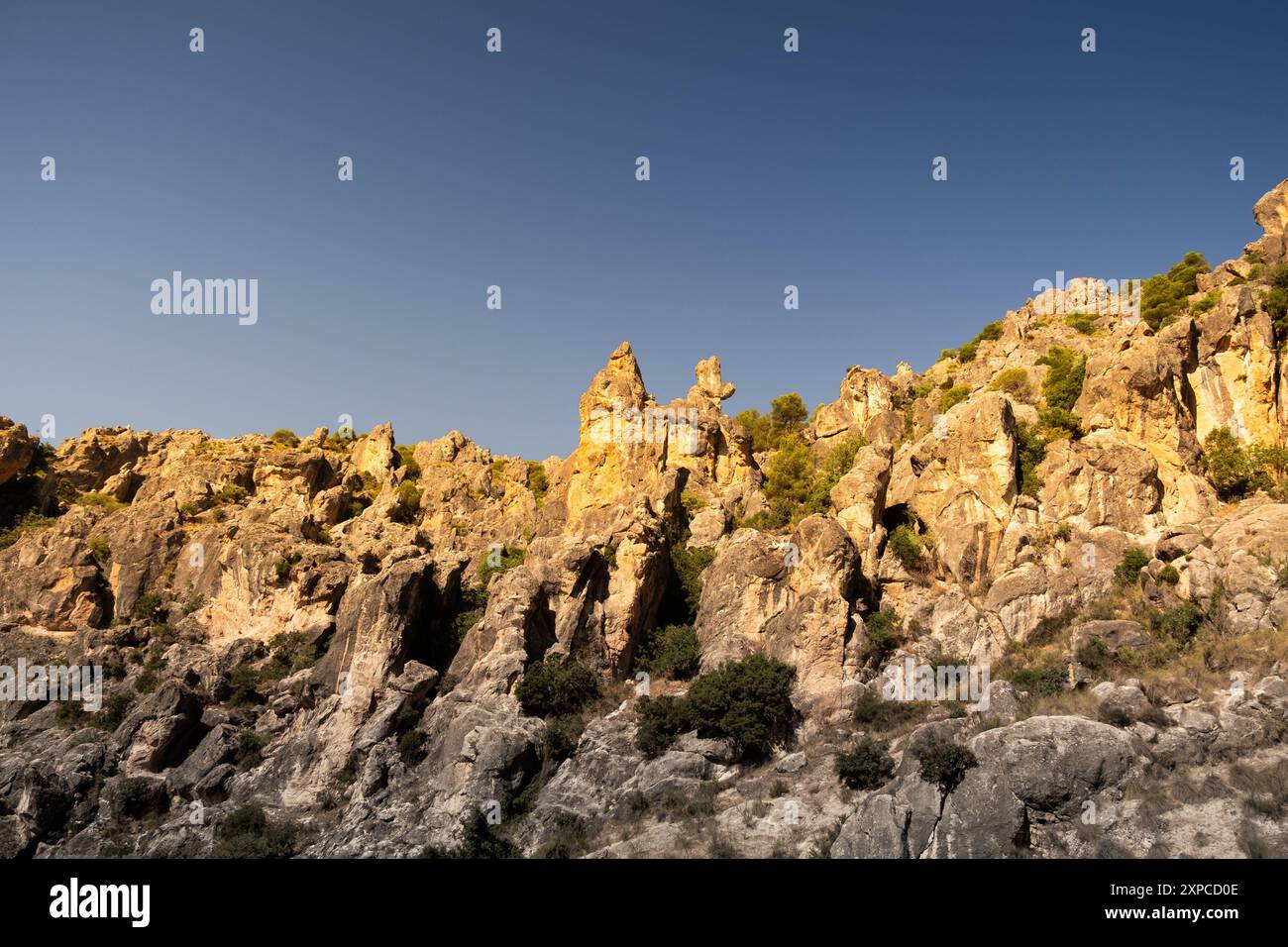 Una formazione rocciosa con bordi ripidi riceve la luce dell'alba nel passo di montagna Despenaperros in Spagna. E' una giornata limpida e soleggiata e le rocce ar Foto Stock
