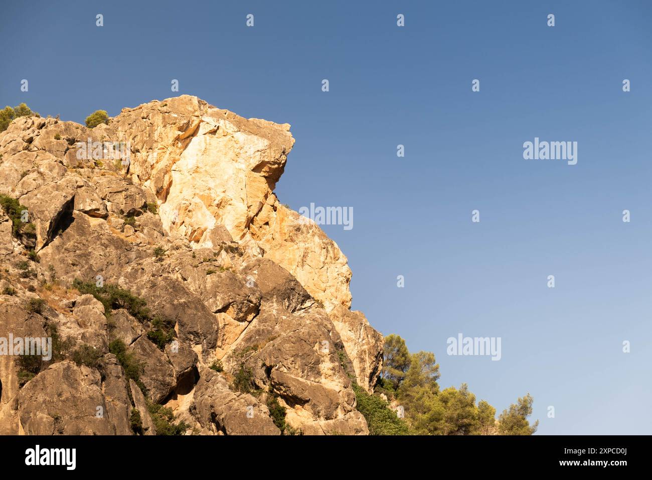 Il dettaglio di una formazione rocciosa a forma di cane riceve la luce dell'alba nel passo di montagna di Despenaperros in Spagna. E' una giornata limpida e soleggiata e la roccia Foto Stock