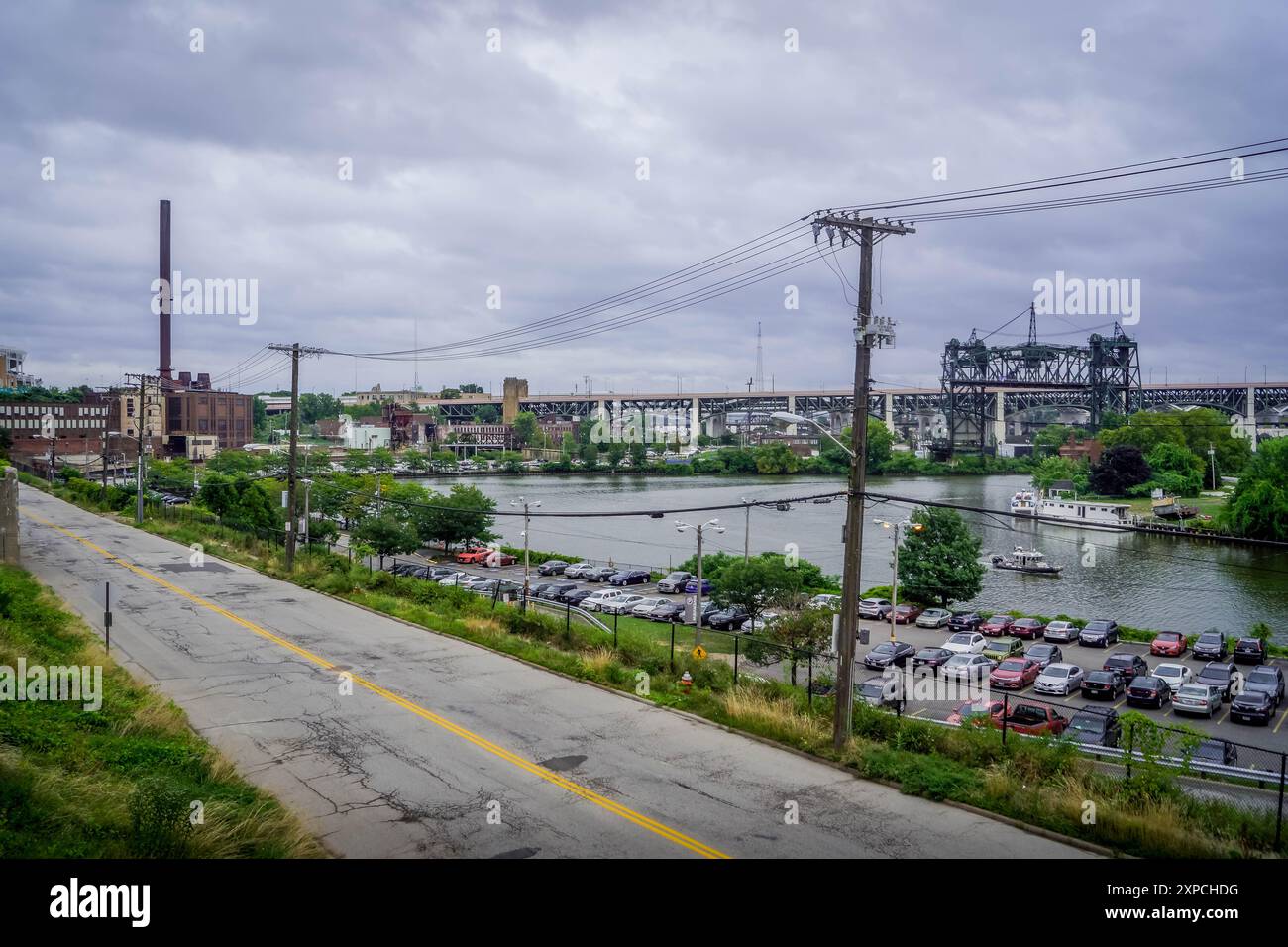 Il parcheggio e la strada sul lungomare del fiume Cuyahoga a Cleveland, Ohio, USA, con il ponte autostradale a ponte verticale Carter Road Bridge Foto Stock