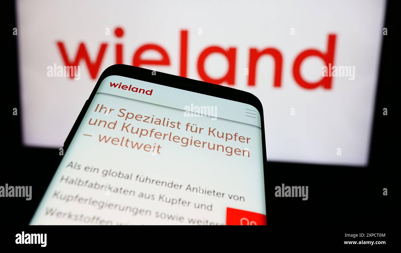 Smartphone con sito web dell'azienda tedesca di lavorazione dei metalli Wieland-Werke AG davanti al logo aziendale. Mettere a fuoco in alto a sinistra sul display del telefono. Foto Stock