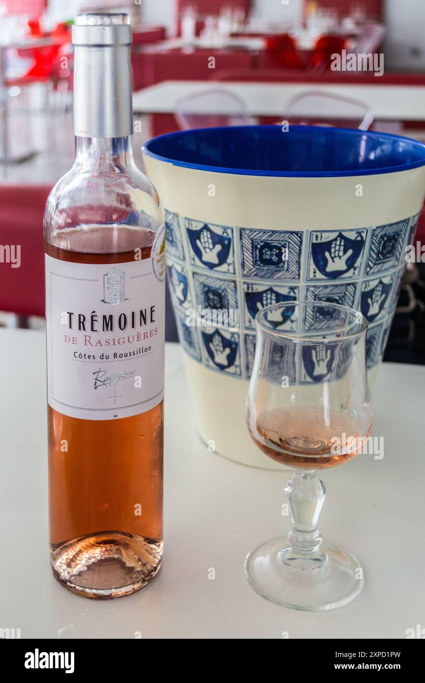 Un bicchiere e mezza bottiglia di vino rosato Roussillon e refrigeratore decorativo in ceramica, Brasserie de la Gare, Perpignan, Pyrénées Orientales, Occitanie, Francia Foto Stock