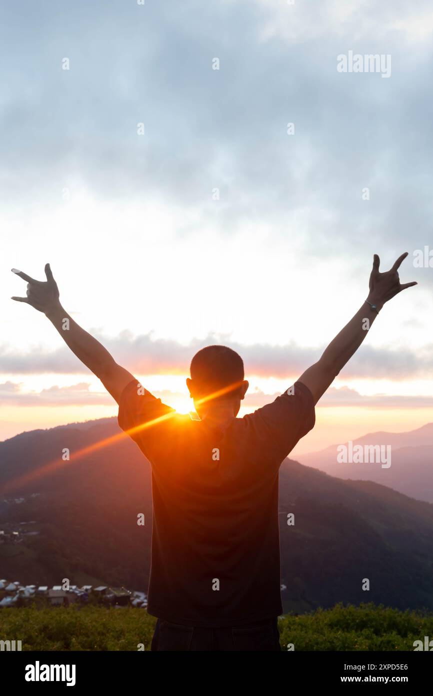 Un giovane regge le parole nel linguaggio dei segni dicendo che ti amo e simboleggia l'amore, la gentilezza e l'amicizia con una bella serenità contro la b Foto Stock