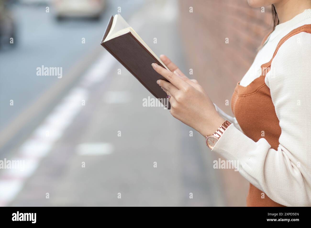 Una giovane donna che tiene una Bibbia per leggere e studiare per comprendere gli insegnamenti di Dio dalla Bibbia che aveva portato con sé e voleva pregare Dio Foto Stock