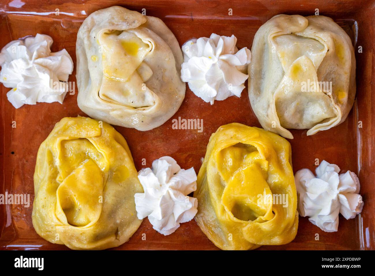 Tipici gnocchi di manti serviti con panna acida, Khiva, Uzbekistan Foto Stock