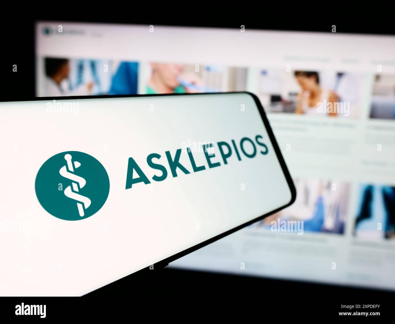 Cellulare con logo della società ospedaliera tedesca Asklepios Kliniken GmbH Co.. KGaA di fronte al sito web aziendale. Mettere a fuoco la parte sinistra del display del telefono. Foto Stock