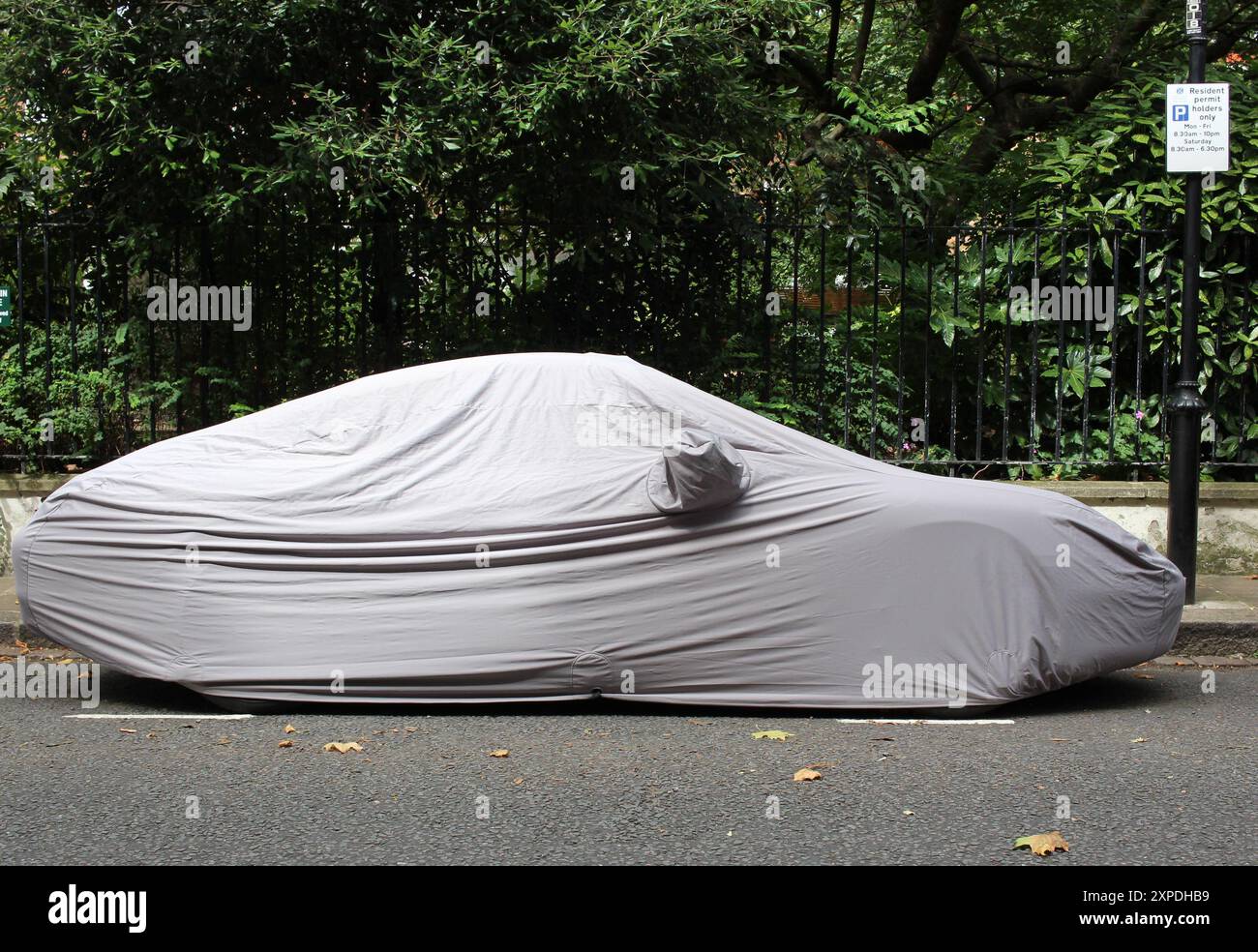 Auto sotto copertura impermeabile per auto stretch nella zona ovest di Londra Foto Stock