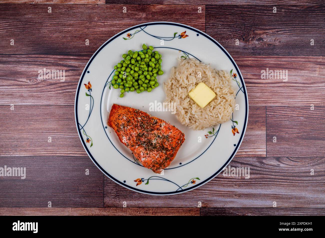 Cena a base di salmone del Pacifico al forno con pepe, aneto e cappero, piselli e riso al gelsomino con burro Foto Stock