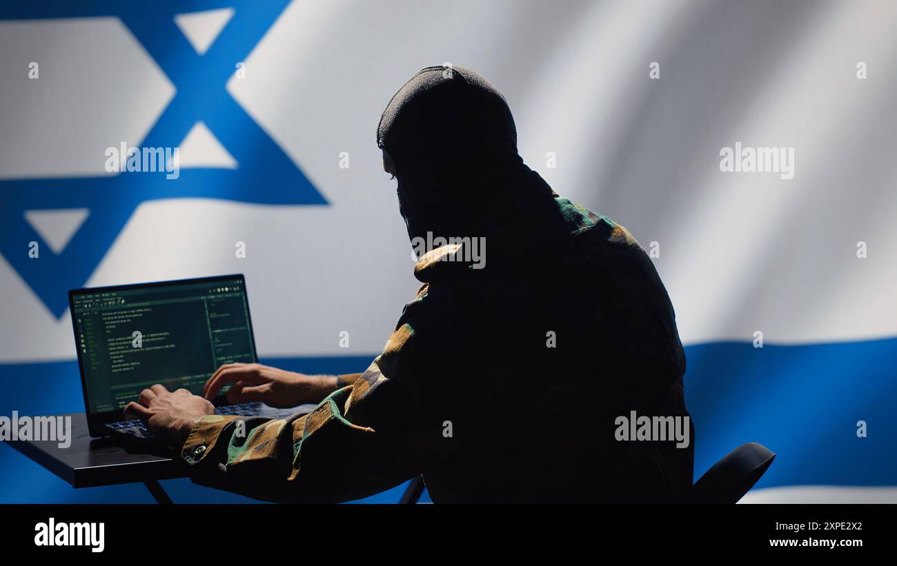 L'agente di polizia segreta di Israele utilizza strumenti di propaganda di massa su laptop per influenzare le menti della popolazione, impegnandosi in operazioni psicologiche. La spia israeliana del Mossad commette sabotaggio PsyOp usando il dispositivo, la telecamera A. Foto Stock