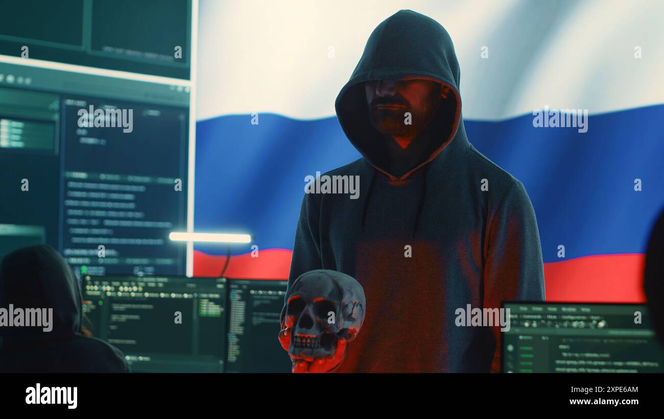 Hacker digitale fuorilegge in un buio buio che emette minacce informatiche con un cranio umano per rendere minacce di morte, intento aggressivo e dannoso. Uomo russo che commette crimini informatici e truffa le nazioni. Telecamera A.. Foto Stock