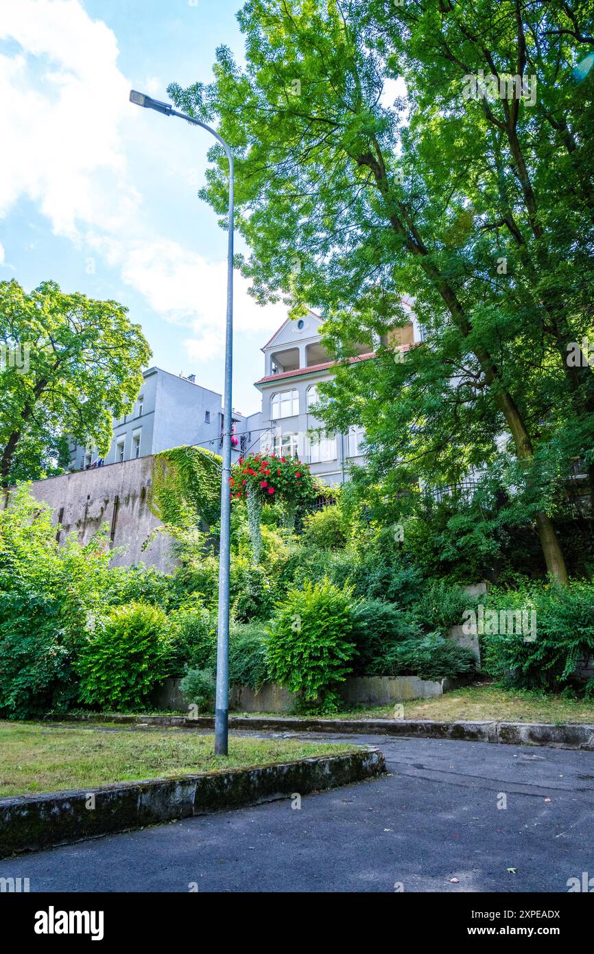 La vegetazione lussureggiante circonda l'edificio storico in una giornata di sole in una tranquilla area suburbana Foto Stock