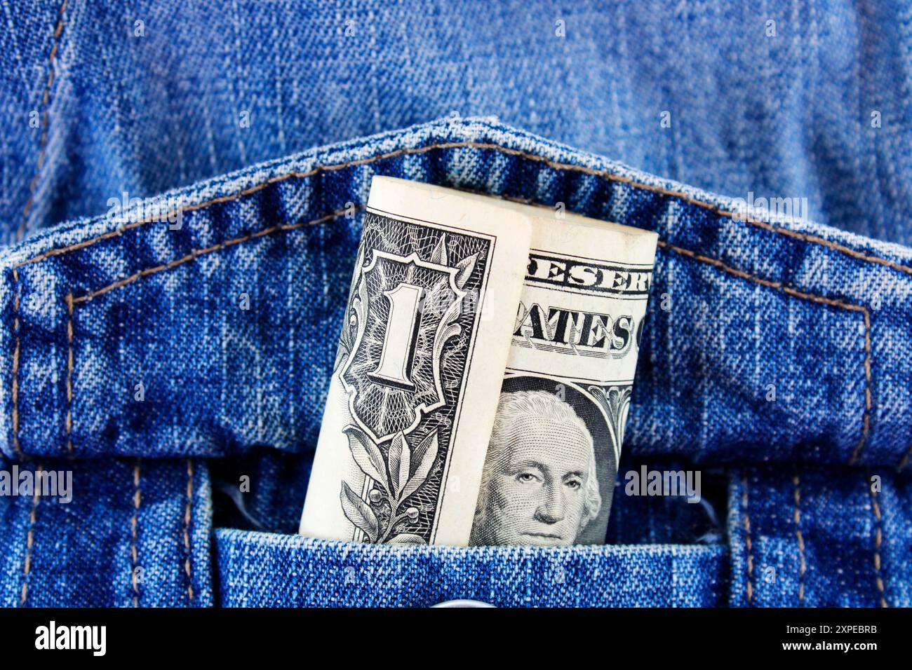 Tasca della giacca in denim contenente una banconota da un dollaro Foto Stock