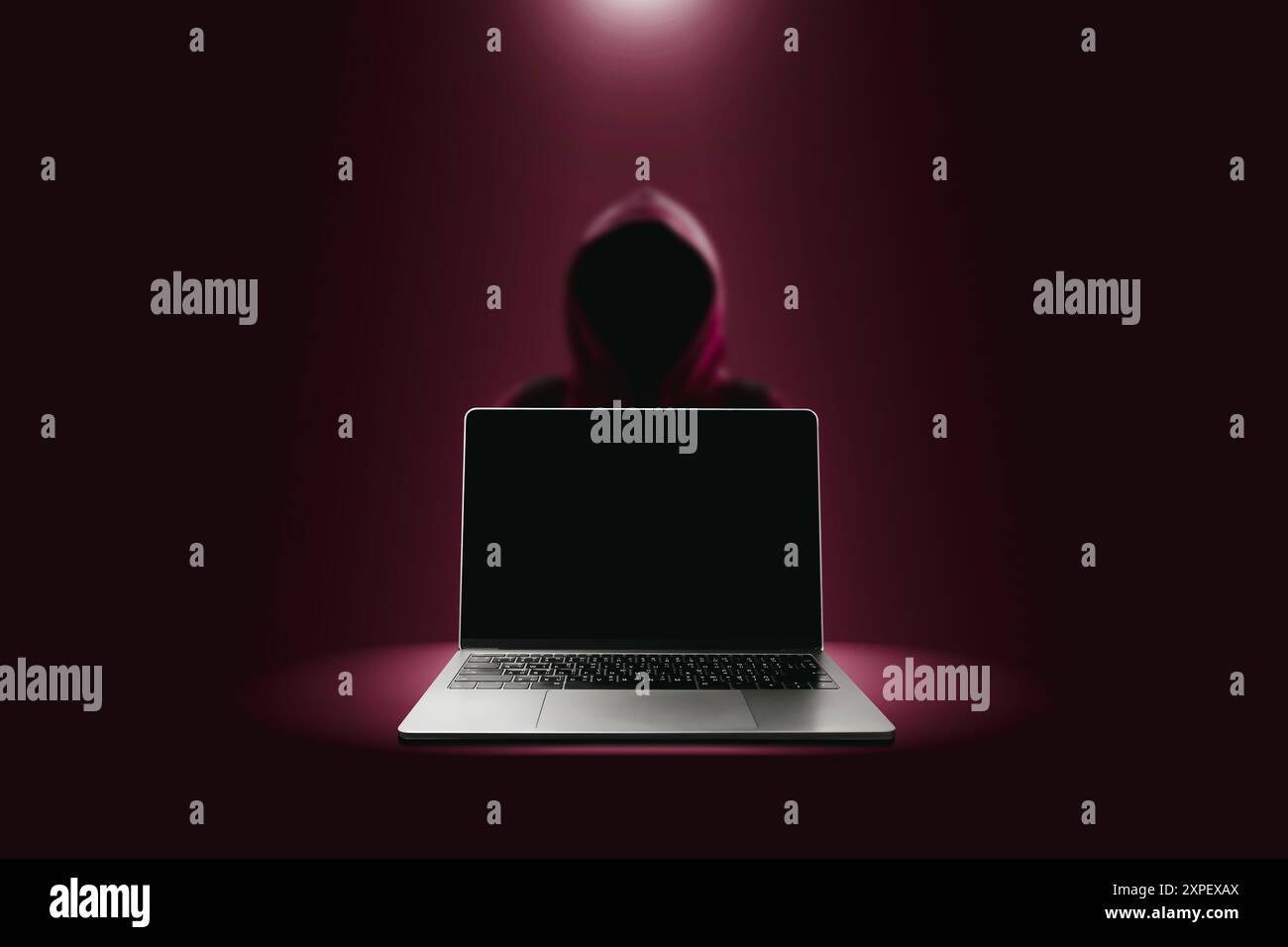 Concetto di tecnologia Crime and Attack di hacker , notebook grigio con schermo nero vuoto e hacker rosso sfocato in uno sfondo rosso scuro Foto Stock