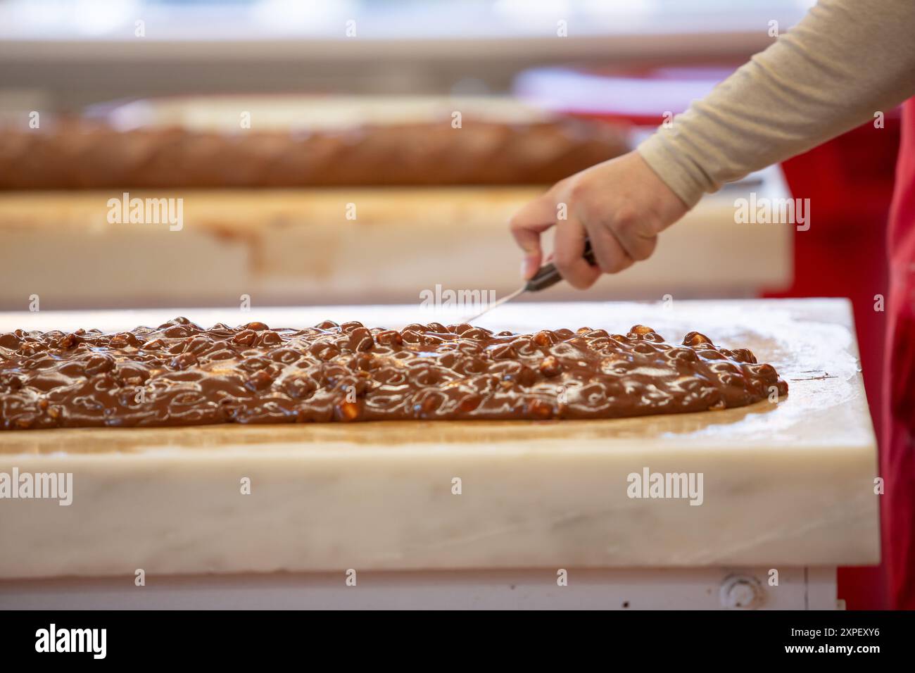 Vista di un dipendente che prepara fudge su una superficie di marmo. Foto Stock