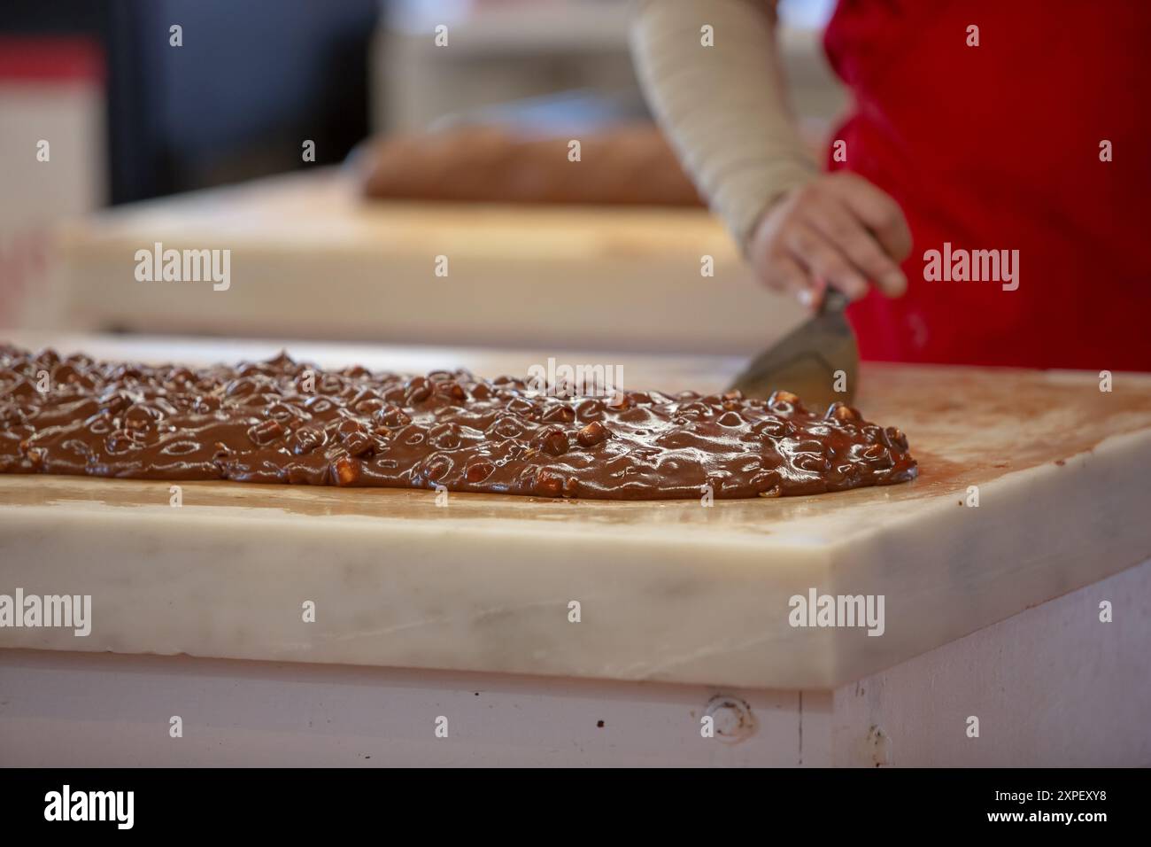 Vista di un dipendente che prepara fudge su una superficie di marmo. Foto Stock